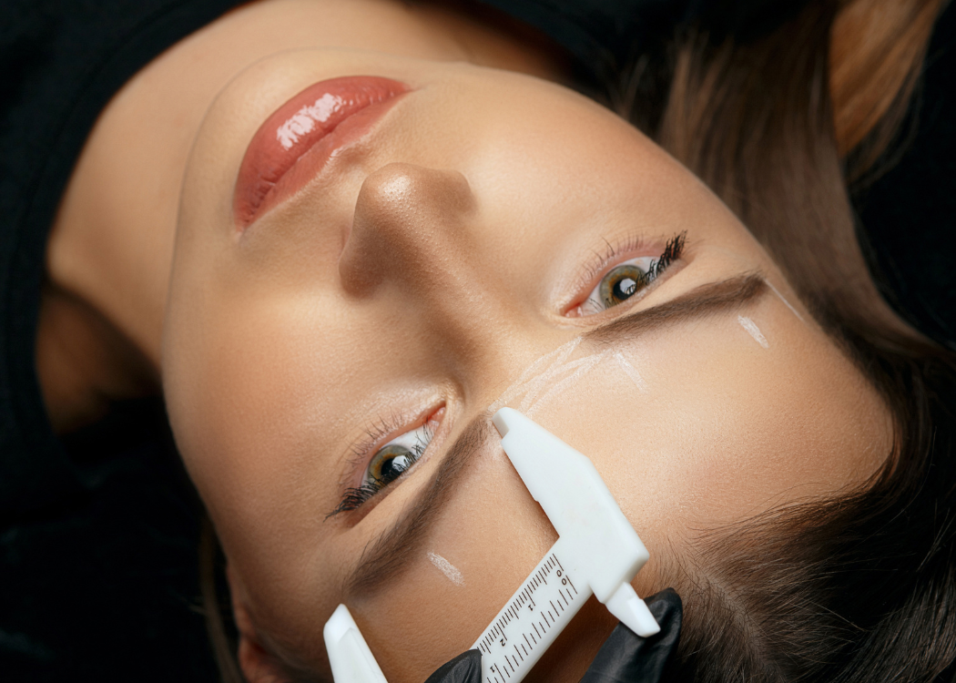 Ausmessen des Gesichts für symmetrisches Permanent Make-up bei Kundin